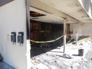 Before: The carport under the building, burned out and taped off.