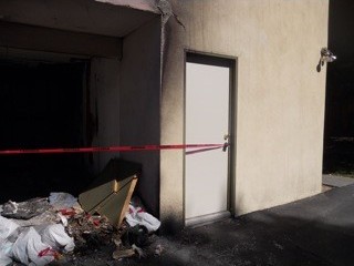 Before: A scorched storage wall and door.